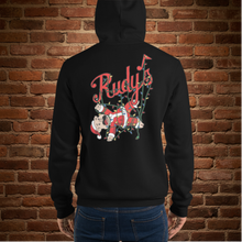 Load image into Gallery viewer, Person showing the back of Rudy’s Bar &amp; Grill Baron Von Swine Christmas Light Edition unisex hoodie, with cartoon pig mascot tangled in Christmas lights and Rudy’s logo, black hoodie, brick wall background