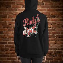 Load image into Gallery viewer, Back view of woman wearing Rudy’s Bar &amp; Grill Baron Von Swine Christmas Light Edition unisex hoodie, with cartoon pig mascot tangled in Christmas lights and Rudy’s logo, black hoodie, brick wall background