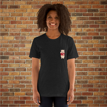 Load image into Gallery viewer, Woman modeling the front of a black heather t-shirt featuring a small Baron Von Swine pig logo on the left chest, posed in front of a brick wall at Rudy’s Bar &amp; Grill.
