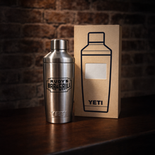 Load image into Gallery viewer, Rudy’s Bar &amp; Grill YETI stainless steel cocktail shaker displayed next to its branded retail box on a bar.