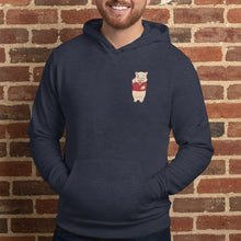 Load image into Gallery viewer, Person wearing Navy blue hoodie featuring a small Baron Von Swine pig mascot graphic on the chest, displayed flat against a reddish-brown textured brick wall background. The hoodie is centered and well-lit for a realistic