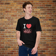 Load image into Gallery viewer, I Love Rudy&#39;s black unisex T‑shirt with Rudy&#39;s Bar &amp; Grill logo on model