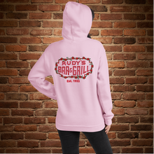 Load image into Gallery viewer, Back of light pink Rudy’s Bar &amp; Grill hoodie featuring neon sign logo and Est. 1933, brick wall background