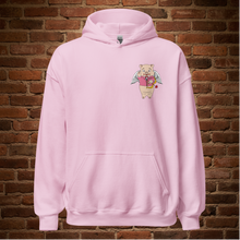 Load image into Gallery viewer, Light pink Rudy’s Bar &amp; Grill hoodie with Cupid Pig graphic on front, brick wall background, no model