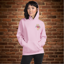 Load image into Gallery viewer, Model wearing light pink Rudy’s Bar &amp; Grill hoodie with Cupid Pig graphic on front, brick wall background