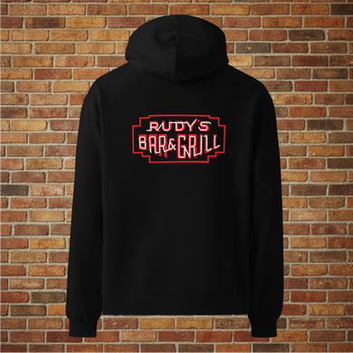 Back view of Rudy’s Bar & Grill Hot Dog Neon Hoodie in black with neon bar sign, displayed against a brick wall background.