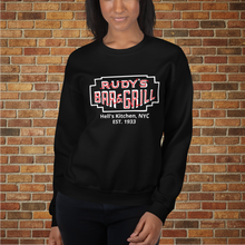 Load image into Gallery viewer, Woman wearing black Rudy’s Bar &amp; Grill Hell’s Kitchen NYC neon sign sweatshirt in front of a brick wall