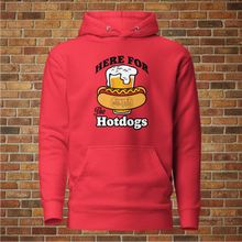 Load image into Gallery viewer, Rudy’s Bar &amp; Grill unisex red hoodie with &quot;Here for the Hotdogs&quot; graphic, front view on brick wall background