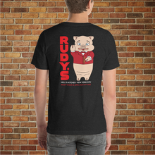 Load image into Gallery viewer, Model showing the back of Classic Rudy’s Bar &amp; Grill black t-shirt, featuring Baron Von Swine mascot and red Rudy’s text, brick wall background