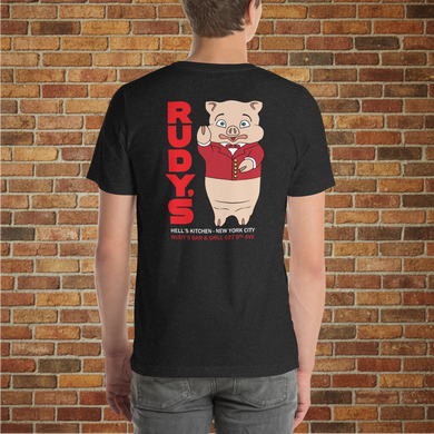 Model showing the back of Classic Rudy’s Bar & Grill black t-shirt, featuring Baron Von Swine mascot and red Rudy’s text, brick wall background