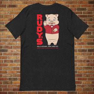 Classic Rudy’s Bar & Grill black t-shirt laid flat, back view featuring Baron Von Swine mascot and red Rudy’s text, brick wall background