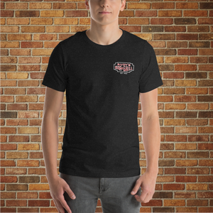 Model wearing Classic Rudy’s Bar & Grill black t-shirt, front view with small logo, standing against a brick wall