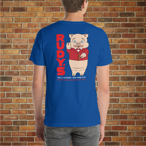 Model showing the back of Classic Rudy’s Bar & Grill true royal blue t-shirt, featuring Baron Von Swine mascot and red Rudy’s text, brick wall background
