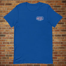Load image into Gallery viewer, Classic Rudy’s Bar &amp; Grill true royal blue t-shirt laid flat, front view with small logo, brick wall background