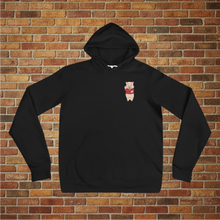 Load image into Gallery viewer, Front view of Rudy’s Bar &amp; Grill Bar Back Hoodie in black with Baron Von Swine mascot chest logo, displayed against a brick wall background