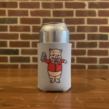 Load image into Gallery viewer, Can koozie featuring Baron Von Swine mascot in a red jacket holding a beer, on a wooden table with a brick wall backdrop