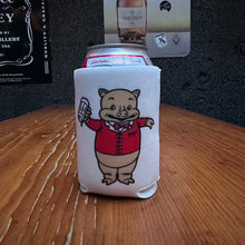Load image into Gallery viewer, Retro pig can koozie featuring Baron Von Swine mascot in a red jacket, displayed on a wooden bar with a dark wall and beverage signage behind