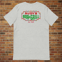 Load image into Gallery viewer, Back of Rudy’s Bar &amp; Grill Christmas Neon Sign T-Shirt – festive neon NYC dive bar logo, flat lay, holiday shirt on brick wall background