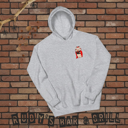 Flat lay of a sport grey hoodie with a small Baron Von Swine devil pig mascot on the chest, arranged on a reddish-brown brick wall background with Halloween-themed props and “Rudy’s Bar & Grill” spelled out at the bottom.