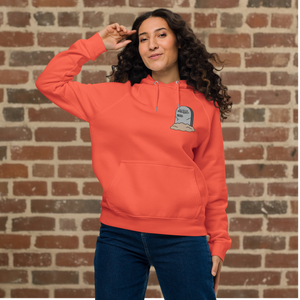 Model wearing Rudy’s Bar & Grill burnt orange Halloween hoodie with tombstone logo on front, Hell’s Kitchen NYC