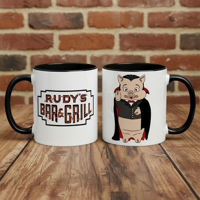 Rudy’s Bar & Grill Halloween coffee mugs showing both sides—one with the classic logo, one with the Dracula Pig design—on a rustic wood bar with a brick wall background