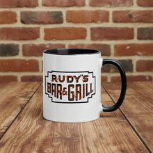 Load image into Gallery viewer, Rudy’s Bar &amp; Grill Halloween coffee mug featuring the classic Rudy’s logo, placed on a rustic wood bar with a brick wall background