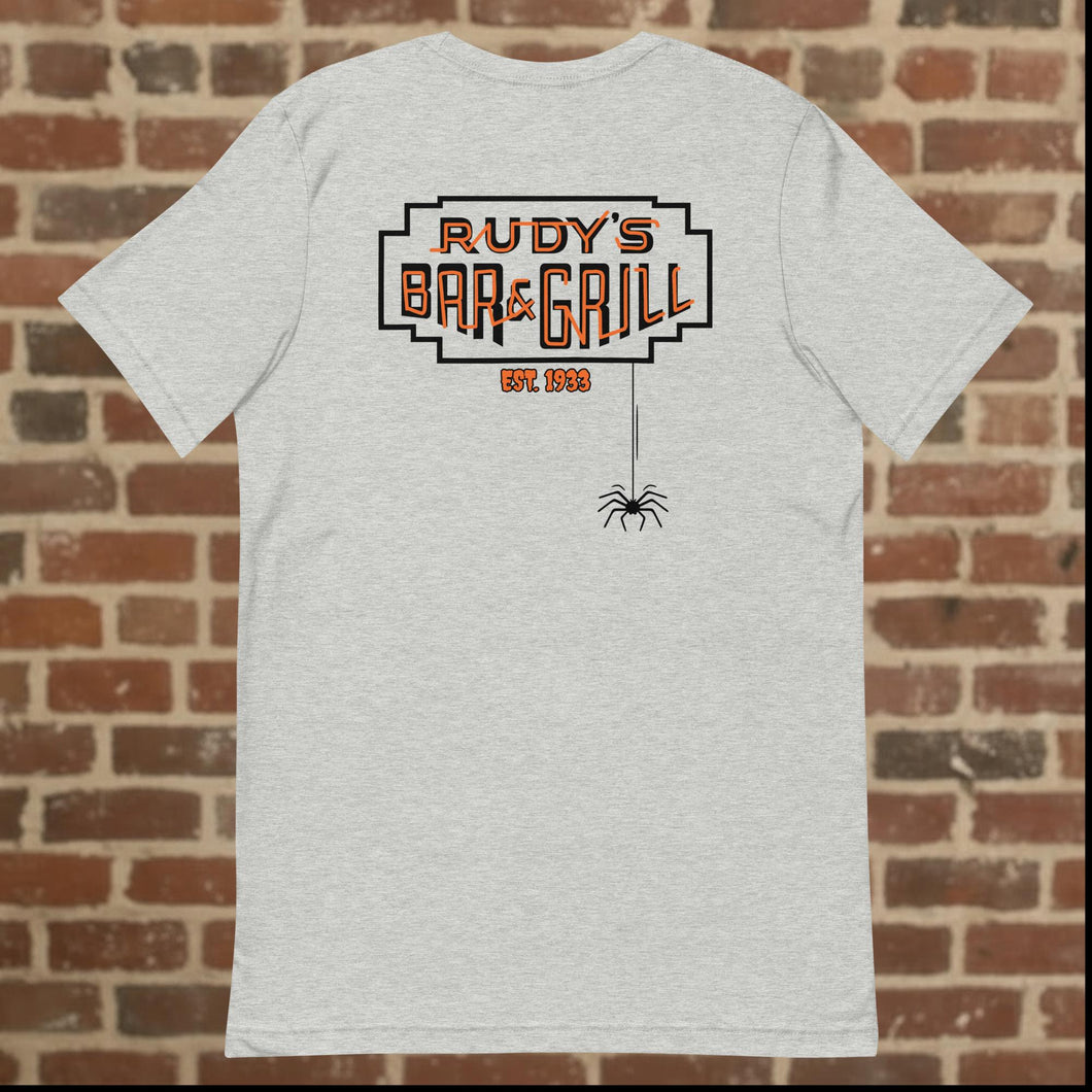 Rudy’s Bar & Grill Halloween t-shirt back in athletic heather, showing the Rudy’s Bar & Grill logo with a spider hanging from the design, displayed against a brick wall background