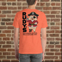 Load image into Gallery viewer, Model wearing Rudy’s Bar &amp; Grill heather orange Halloween t-shirt showing back design with Baron Von Swine as pirate, Hell’s Kitchen NYC