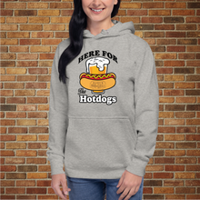 Load image into Gallery viewer, Woman wearing Rudy’s Bar &amp; Grill “Here For the Hotdogs” hoodie in carbon grey, front view, with beer and hot dog graphic, standing in front of a brick wall.
