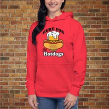 Load image into Gallery viewer, Woman wearing Rudy’s Bar &amp; Grill “Here For the Hotdogs” hoodie in red, front view, with beer and hot dog graphic, standing in front of a brick wall.
