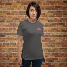 Load image into Gallery viewer, Person wearing Rudy’s Bar &amp; Grill Saxophone Pig T-shirt in asphalt gray, front view, standing in front of a brick wall.
