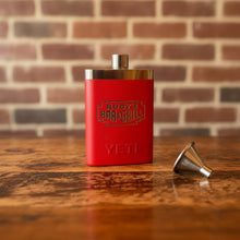 Load image into Gallery viewer, Rudy’s Bar &amp; Grill red Yeti flask and stainless steel funnel on a rustic wood table, with a classic brick wall backdrop