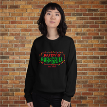 Load image into Gallery viewer, Woman wearing Rudy’s Bar &amp; Grill Christmas Neon Sign Sweatshirt in black, front view, brick wall background
