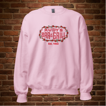 Load image into Gallery viewer, Light pink Rudy’s Bar &amp; Grill neon sign Valentine’s Day sweatshirt on brick wall background