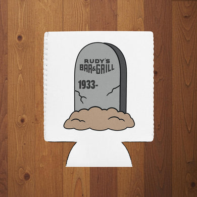 Rudy’s Bar & Grill Halloween can cooler in regular size featuring a tombstone graphic with “Rudy’s Bar & Grill 1933–” on a white koozie, wood background