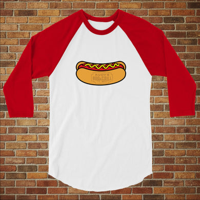 Rudy’s Bar & Grill Hot Dog 3/4 Sleeve Baseball Shirt in white with red sleeves, featuring a hot dog graphic, displayed flat against a brick wall background