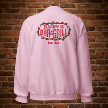Load image into Gallery viewer, Light pink crew neck sweatshirt with Rudy’s Bar &amp; Grill neon sign and “Est. 1933” on the back, displayed flat against a brick wall background