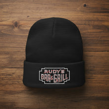 Load image into Gallery viewer, Rudy’s Bar &amp; Grill Neon Sign Cuff Beanie laying flat on a rustic wood surface