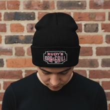 Load image into Gallery viewer, Male model wearing Rudy’s Bar &amp; Grill Neon Sign Cuff Beanie, looking down in front of a brick wall
