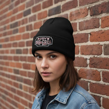 Load image into Gallery viewer, Female model wearing Rudy’s Bar &amp; Grill Neon Sign Cuff Beanie in front of a brick wall