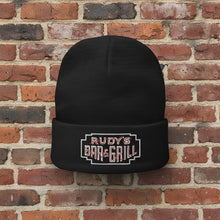 Load image into Gallery viewer, Rudy’s Bar &amp; Grill Neon Sign Cuff Beanie displayed against a brick wall