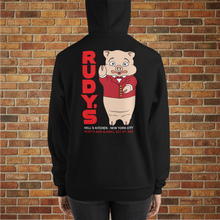 Load image into Gallery viewer, Back view of black hoodie featuring Rudy’s Bar &amp; Grill pig mascot and Hell’s Kitchen NYC address, shown on model in front of brick wal