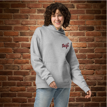 Load image into Gallery viewer, Woman wearing Rudy’s Bar &amp; Grill Valentine’s Day NYC Edition oversized hoodie, front view – script Rudy’s logo on athletic heather gray, brick wall background