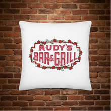 Load image into Gallery viewer, Rudy’s Bar &amp; Grill Valentine’s Day pillow front – red rose border logo on white pillow, brick wall background