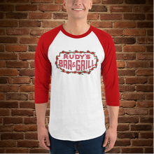 Load image into Gallery viewer, Man wearing Rudy’s Bar &amp; Grill Valentine’s Day neon sign raglan shirt, red sleeves, brick wall background