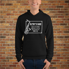Load image into Gallery viewer, Man wearing a black Rudy’s Bar &amp; Grill Jazz Saxophone Unisex Hoodie, standing in front of a brick wall background