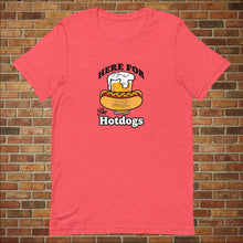 Load image into Gallery viewer, Heather red &quot;Here for the Hot Dogs&quot; T-shirt from Rudy’s Bar &amp; Grill, displayed flat in front of a brick wall background
