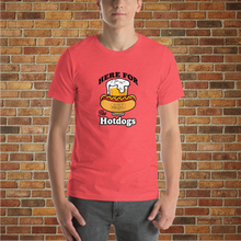 Load image into Gallery viewer, Man wearing a heather red &quot;Here for the Hot Dogs&quot; T-shirt from Rudy’s Bar &amp; Grill, standing in front of a brick wall background