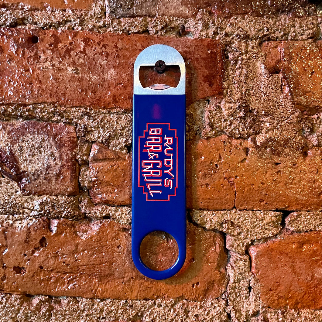 udy’s Bar & Grill neon sign bartender bottle opener hanging on a brick wall