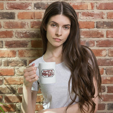 Load image into Gallery viewer, Woman in a light gray shirt holding an 11oz white mug with the Rudy’s Bar &amp; Grill neon sign logo, seated against a rustic brick wall